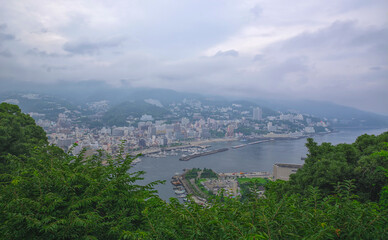 Fototapeta premium Aerial view of Atami, a seaside resort town southwest of Tokyo, on a cloudy summer day