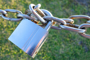 Padlock and chain with a green background.