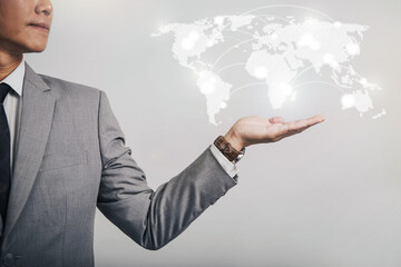 Businessman holding global network and data exchanges over the worldmap. Businessman touch world map and connection. Hand holding abstract globe with connections on world background.
