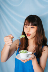 Asian dark hair woman eating sweet green sticky rice.