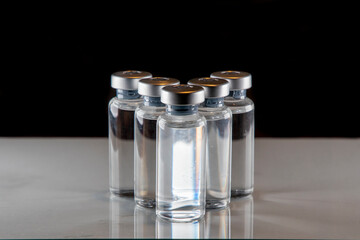 five vaccine containers with a black background to be used as coronavirus vaccine development