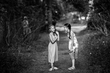 Fototapeta premium Two ten-year-old girls friends in pine Park.. Black and white photography.