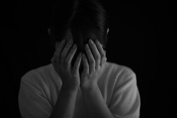 手で顔を覆う女性