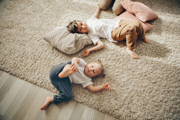 children playing together. Happy kids: brother and sister lying on the floor.