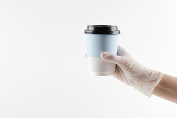 human hand in white gloves holding take away paper cup for coffee or tea on white background.