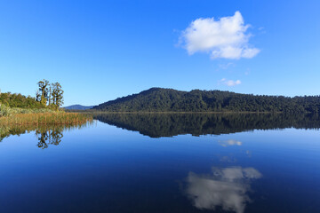 Calm mirror lake in the morning with mountain background in New Zealand.