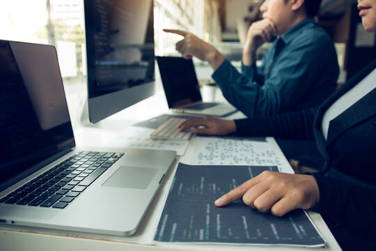 Two software developers are analyzing together about the code written into the program on the computer.