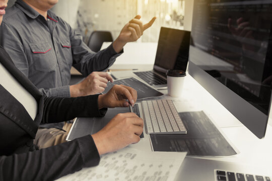 Two asian team working development of programming and encryption technology website design programmers on desk in office.