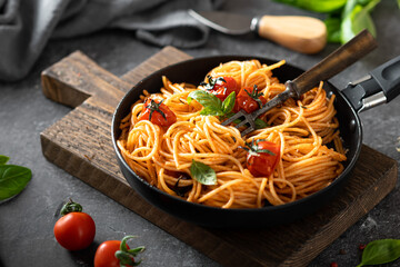 pasta in a black pan on a dark background , italian cuisine, selective focus - obrazy, fototapety, plakaty