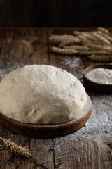 Fototapeta na wymiar dough in an old bakery on a wooden background with flour