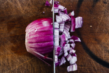 simple food ingredients, half whole half chopped red onion on cutting board with knife