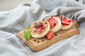 A healthy breakfast of pancakes, strawberries, chocolate, and honey