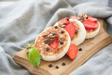 A healthy breakfast of pancakes, strawberries, chocolate, and honey