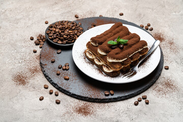 Classic tiramisu dessert on ceramic plate on concrete background