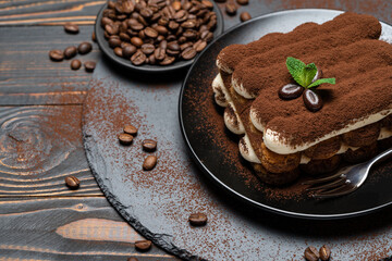 Classic tiramisu dessert on ceramic plate on wooden background
