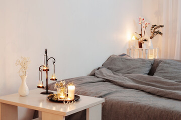 night interior of bedroom with flowers and burning candles
