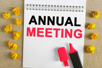 The text is written in the notebook - ANNUAL MEETING. There is a marker on the notebook, next to it is crumpled yellow paper.