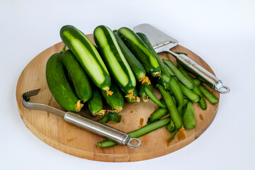 Fresh cucumbers peeled on wooden tray with tool and copy space