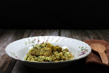 Traditional fried and stirred spicy cooked jasmine rice with chopped pork belly, chilly and basil seasoning with pepper and turmeric powder on the plate. Famous hot and spicy street food menu. 