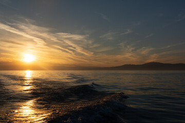 Obraz premium Couché de soleil sur le lac Léman avec bateau à voile en silhouette
