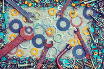 Abstract grunge colorful metal background made of bolts, screws, nuts, and wrenches