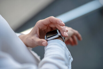 Close up picture of a womans hands touching a smartwatch
