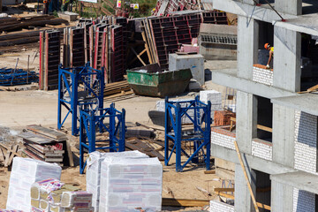 Noisy construction site in the middle of the city. building new modern block-of-flats. Active urban development and summer constructions