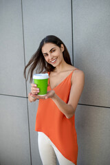 Cute young woman holding a cup with coffee