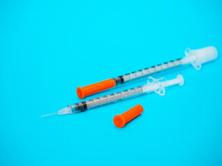Insulin vial and syringe on blue background. Health care, doctor, clinic or hospital, medical concept. World diabetes day. Ready for vaccine injection. Pain treatment, illegal use, vaccination