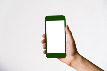 Hand holding white mobile phone with mint green white screen in white background.