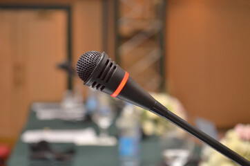 Microphone turned on on a table with a close-up in a conference room with a blurry background
