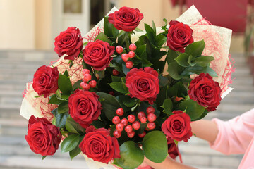 Large and beautiful bouquet of roses close up in the hands of young girl