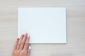 Fototapeta premium White board with hands for copy space. School office supplies on wooden background. Back to school concept. Top view ready for your design.
