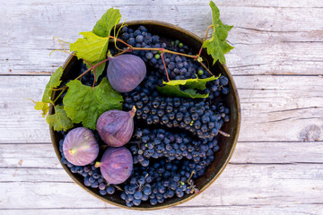 Ripe grapes and figs on a vintage plate.
