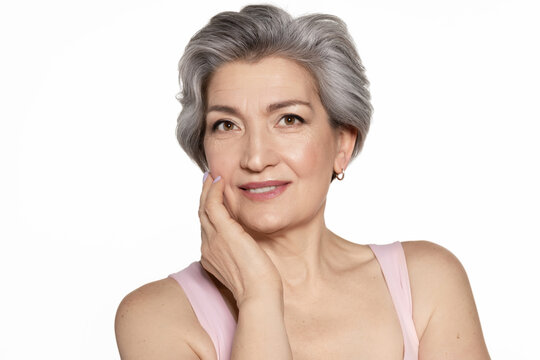 Grey-haired beautiful senior woman touch perfect skin 