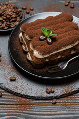 Classic tiramisu dessert on ceramic plate on wooden background