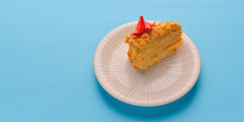 Crepes cake with cottage cheese and strawberry served on a white plate. Strawberry cake over pastel blue background.