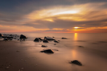 Boulders in the sea in the Wolin National Park in the light of the setting sun, Poland