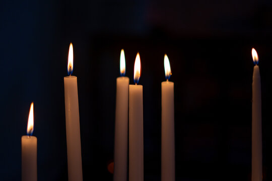 Candle flame close-up in church for religious ritual. Black background. High quality photo