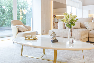 trendy modern interior design of a large studio in white and beige colors with large floor-to-ceiling windows. area of ​​white kitchen with an island and a recreation area