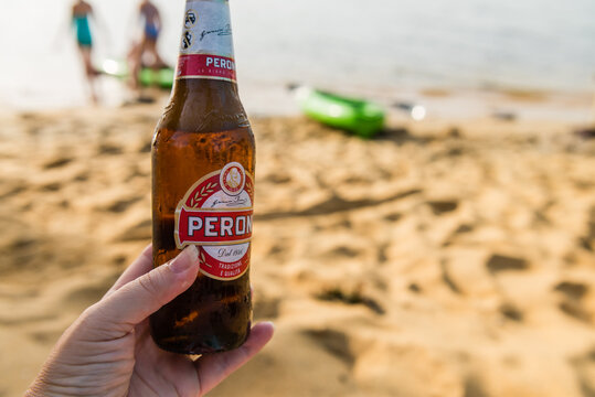 peroni beer in hand at the beach