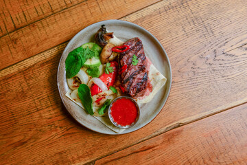 Georgian cuisine concept. Grilled meat with vegetables and sauce.