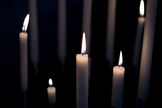 Candle flame close-up in church for religious ritual. Black background. High quality photo