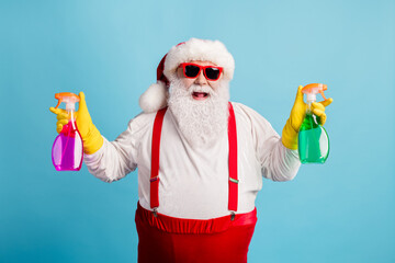 Portrait of his he nice attractive cheerful cheery glad overweight Santa cleaning up holding in hands supplies chemical isolated bright vivid shine vibrant blue color background