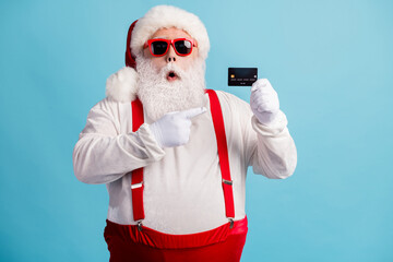 Fototapeta na wymiar Portrait of his he nice attractive amazed stunned white-haired Santa demonstrating credit card service finance advert loan cash pout lips isolated bright vivid shine vibrant blue color background