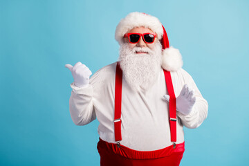 Fototapeta na wymiar Portrait of his he nice attractive cheerful cheery white-haired Santa demonstrating copy space advice advert ad look idea pulling suspender isolated bright vivid shine vibrant blue color background