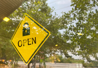 Open sign yellow board hanging on the coffee cafe shop door for welcome.