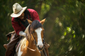 Cowboy in red dress and pure horse standing in the forest
