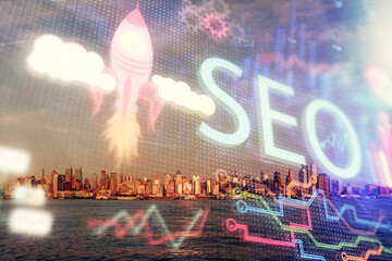 SEO hologram on city view with skyscrapers background double exposure. Search optimization concept.