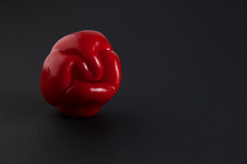 Ugly red bell pepper on dark background with copy space. Concept - reduction of food organic waste. Deformed, crooked vegetables and fruits can be eaten